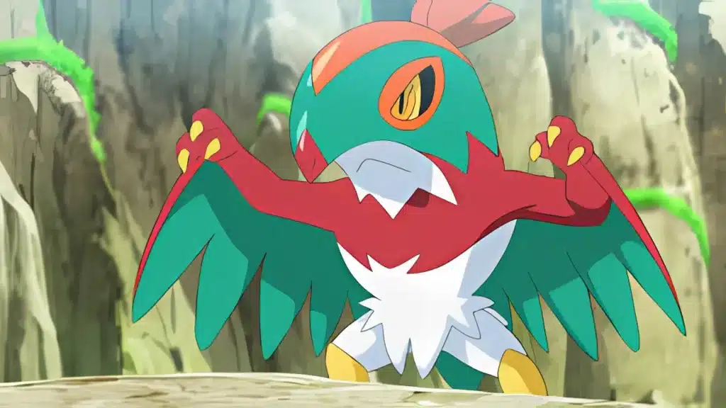 Hawlucha spreading its wings in a battle stance, showing its red and green body against a rocky backdrop