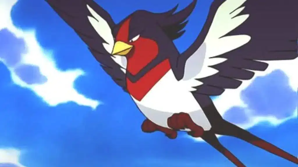 Swellow flying swiftly through the sky with wings spread wide, showing its red chest and sharp focused expression