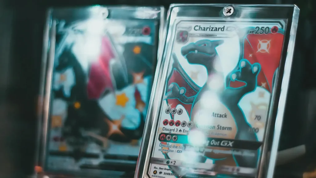 Charizard GX Pokémon card in protective case with shiny black variant blurred in background