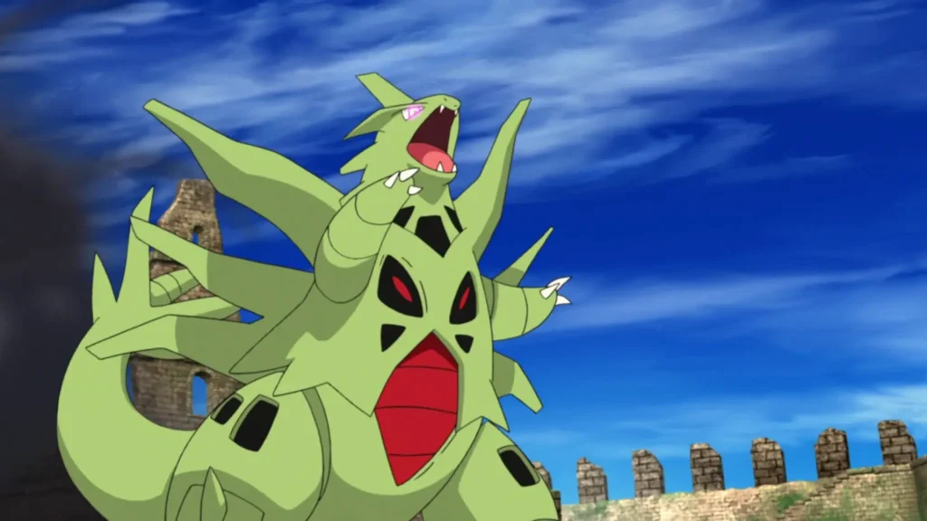Mega Tyranitar roaring in anime scene with red chest, wings spread, and ancient stone ruins in background